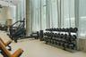 Fitness facility featuring floor-to-ceiling windows, neutral tile flooring, and a concrete structural pillar
