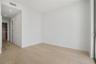 Neutral interior featuring light-tone wood-finish flooring, recessed lighting, and a walk-in closet with built-in shelving
