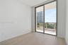 Wood-finish flooring, floor-to-ceiling sliding glass doors, and access to a private balcony