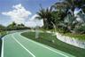 Outdoor fitness circuit featuring a synthetic running track, artificial turf area, built-in exercise equipment, and tiered stone retaining walls surro