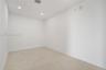 Interior space featuring neutral stone-finish flooring, crisp white walls, and recessed ceiling lighting