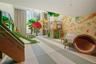 Recreational space featuring custom built-in wood climbing structures, integrated slide, large-scale wall murals, and floor-to-ceiling windows