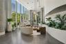 Floor-to-ceiling glass windows, concrete structural columns, polished concrete flooring, recessed lighting, and curved architectural wall detail