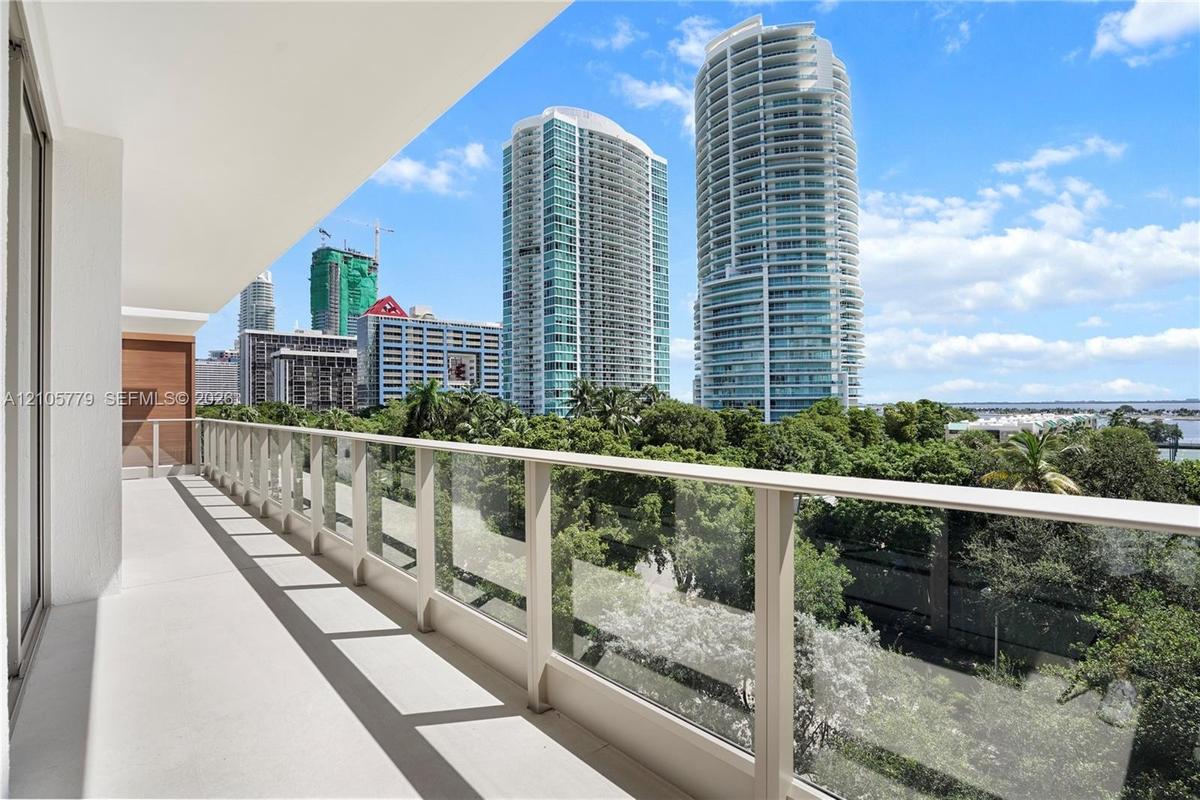 Covered balcony with smooth concrete flooring and a transparent glass panel railing