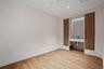 Room featuring wood-finish flooring, curved wall architecture, built-in floor-to-ceiling wood cabinetry, and a stone-surround recessed vanity with int