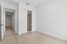 Neutral interior featuring wood-finish flooring, sliding closet doors, and built-in shelving