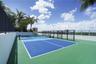 Rooftop recreation court featuring a multi-toned surface, black metal perimeter fencing, and glass paneling