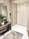 Private elevator access featuring floor-to-ceiling high-gloss finish doors, polished tile flooring, and textured wall coverings with recessed lighting