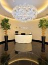 Rotunda entry featuring a large sculptural chandelier, polished black stone flooring with linear inlay patterns, textured wall finishes, and a custom 