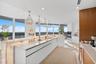 A true culinary masterpiece, this world-class chef's kitchen showcases bespoke White Oak cabinetry, sleek high-gloss white cabinetry, luxurious glossy