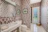 Pedestal sink with polished chrome widespread faucet, expansive wall-to-wall mirror, patterned wallpaper, and glass-paneled exterior door featuring ti