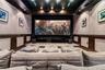 Dedicated screening room featuring a tiered floor, custom wood wainscoting, recessed ceiling lighting, and integrated wall paneling