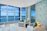 This room tells a story. The wallpaper doesn't compete with the ocean—it complements it. The soft blues and gold accents echo the colors of the sea an