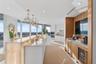 The spectacular chef's kitchen is a true showpiece, centered around a breathtaking backlit Cristallo natural stone island and countertops that radiate