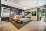Tray ceiling with recessed lighting, wood-finish flooring, textured wall covering, wall-mounted accent lighting, and glass door entry to exterior spac