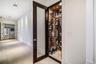 300-bottle, climate-controlled wine storage featuring a wood-finish door with glass inset, structured metal racking, and recessed interior lighting