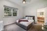 Neutral-toned room featuring a multi-pane window, wall-to-wall striped carpeting, and a ceiling-mounted light fixture