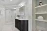 A Private Spa Bath for the Guest Wing — Completing the accommodations is a beautifully appointed en-suite bath, finished in luminous marble-inspired s
