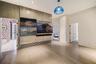Wood-finish wall paneling with integrated media station, recessed ceiling lighting, and blue glass pendant fixture