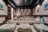 Media room featuring tiered flooring, fabric-paneled walls, built-in A/V rack, recessed ceiling lighting, and crown molding