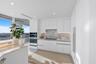 This magnificent chef's kitchen is a masterpiece of contemporary design, where luminous high-gloss white cabinetry is beautifully complemented by besp