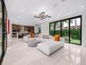 Open-concept living space featuring large-format tile flooring, multi-panel sliding glass doors, built-in cabinetry, recessed lighting, and a modern t