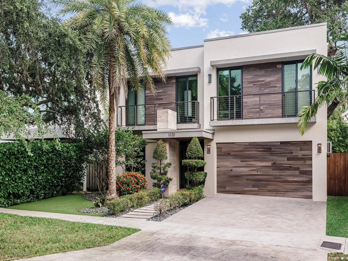 Modern two-story exterior featuring smooth stucco siding, horizontal wood-finish cladding, second-level balconies with metal railings, and an attached
