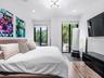 Wood-finish flooring, dual sliding glass doors, recessed lighting, and a multi-arm modern light fixture