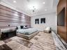Large-format tiled flooring, recessed ceiling lighting, multi-arm modern chandelier, paneled wall feature, and built-in wood-finish media wall