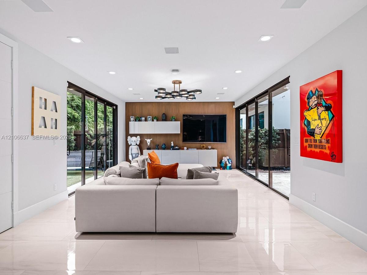 Large-format tile flooring, dual floor-to-ceiling glass sliding door systems, wood-paneled feature wall with built-in cabinetry, and multi-light geome