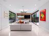 Large-format tile flooring, dual floor-to-ceiling glass sliding door systems, wood-paneled feature wall with built-in cabinetry, and multi-light geome