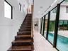 Staircase featuring dark wood treads and a linear handrail, large-format tile flooring, recessed ceiling lighting, and floor-to-ceiling glass wall pan