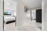 Large-format polished tile flooring, neutral wall tones, recessed lighting, and dark-finish interior doors