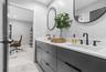 Modern dual-sink vanity featuring matte black hardware, integrated cabinetry with flat-panel doors, solid surface countertops, and dual wall-mounted o
