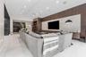 Vaulted ceilings, large-format tile flooring, recessed lighting, and a custom floor-to-ceiling accent wall featuring vertical wood-slat paneling with 