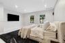 Neutral-toned interior featuring recessed lighting, large-format tile flooring, and dual windows with outdoor greenery