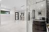 Entryway featuring large-format light tile flooring, recessed ceiling lighting, a dark-framed multi-panel front door, and a climate-controlled glass-e