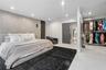 Bedroom featuring tile flooring, recessed lighting, a textured accent wall with vertical slat detailing, and an open-concept built-in closet system