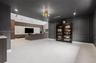 Large format tile flooring, charcoal-painted walls with decorative wainscoting, statement gold-tone ceiling fixture, recessed lighting, and a custom m