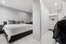 Neutral interior featuring large-format tile flooring, recessed lighting, and built-in closet organization system with integrated drawers and shelving