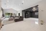 Open-concept interior featuring vaulted ceilings, oversized tile flooring, recessed lighting, and expansive glass sliding doors