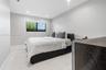 Neutral-toned interior featuring large-format tile flooring, recessed lighting, and a window with a black frame