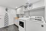 Laundry area featuring built-in cabinetry, a wood-finish countertop, a drop-in sink with a gooseneck faucet, and wood-finish flooring