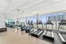 Fitness room featuring floor-to-ceiling windows, full-length wall mirrors, and resilient flooring