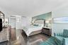 Wood-finish tile flooring, textured teal accent wall, recessed ceiling lighting, and double-door closets