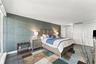 Textured accent wall, large-format polished flooring, and dual-panel interior doors