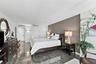 Room featuring high-gloss stone-finish flooring, a textured accent wall, dual-panel interior doors, and integrated recessed wall lighting
