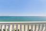Private balcony featuring white vertical balusters and an oceanfront horizon