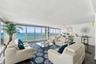 Floor-to-ceiling windows featuring ocean scenery, wood-finish flooring, and recessed ceiling lighting