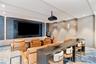 Media space featuring a recessed wall display, integrated vertical accent lighting, textured wall coverings, and a ceiling-mounted projection system